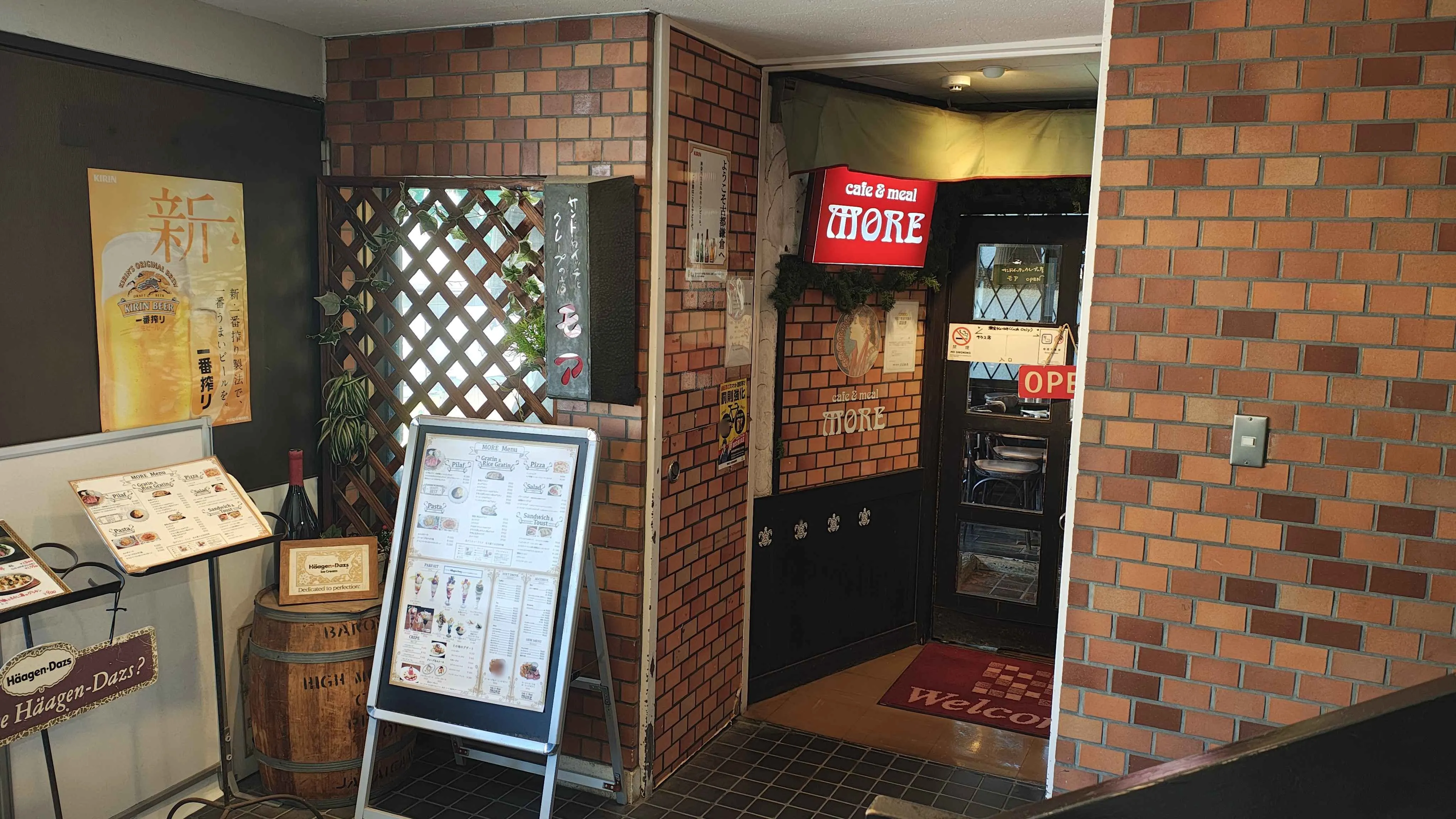 レンガ調の壁にメニュー看板が置かれた喫茶モアの入口