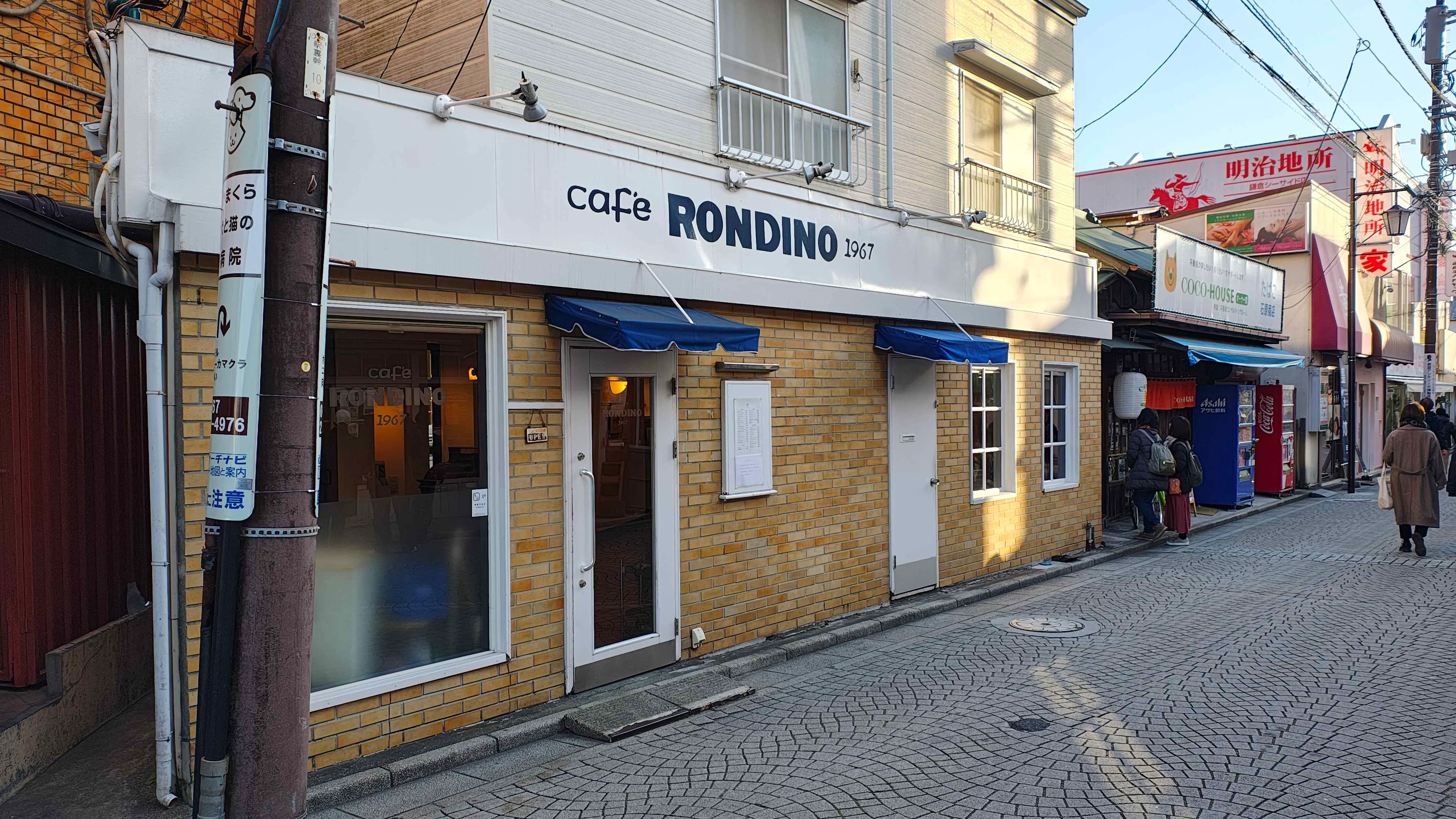 御成商店街の入口に建つ cafe RONDINO の外観。青い日除けに 1967 の文字