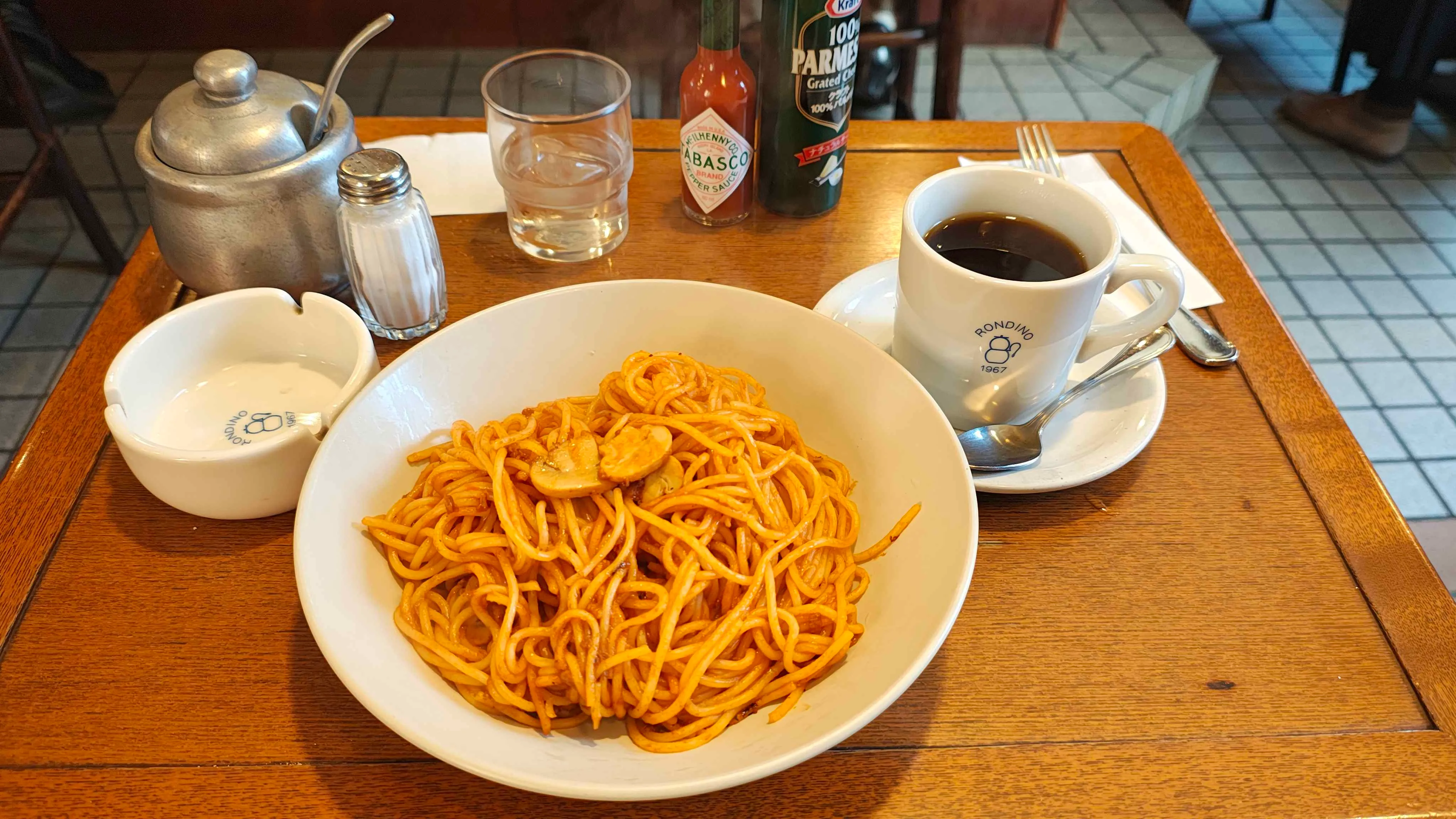 cafe RONDINO のスパゲッティとコーヒー。テーブルには灰皿とタバスコが置かれている