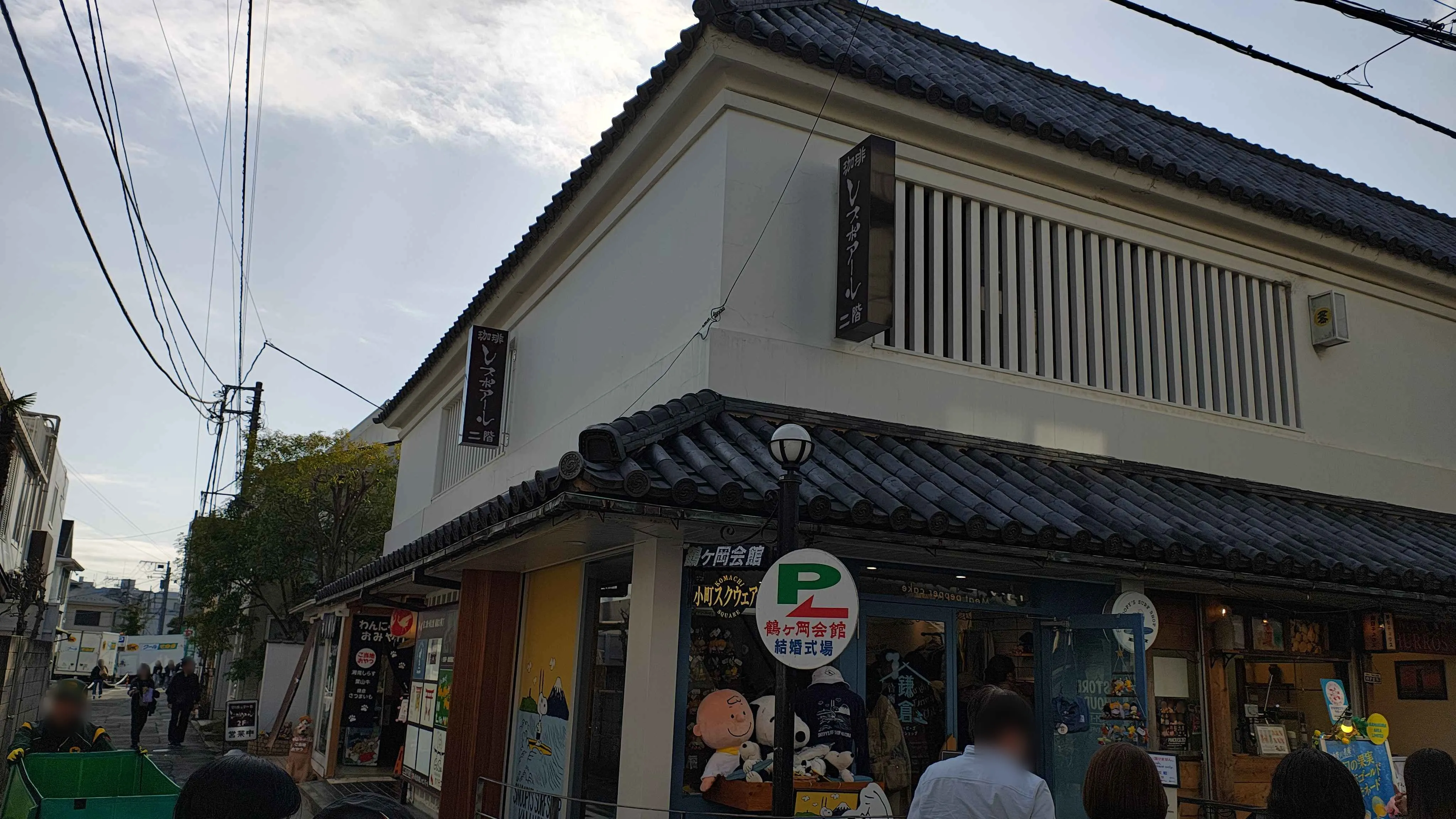 レスポワールが入る、白壁に瓦屋根の商業ビルを通りから見上げたところ