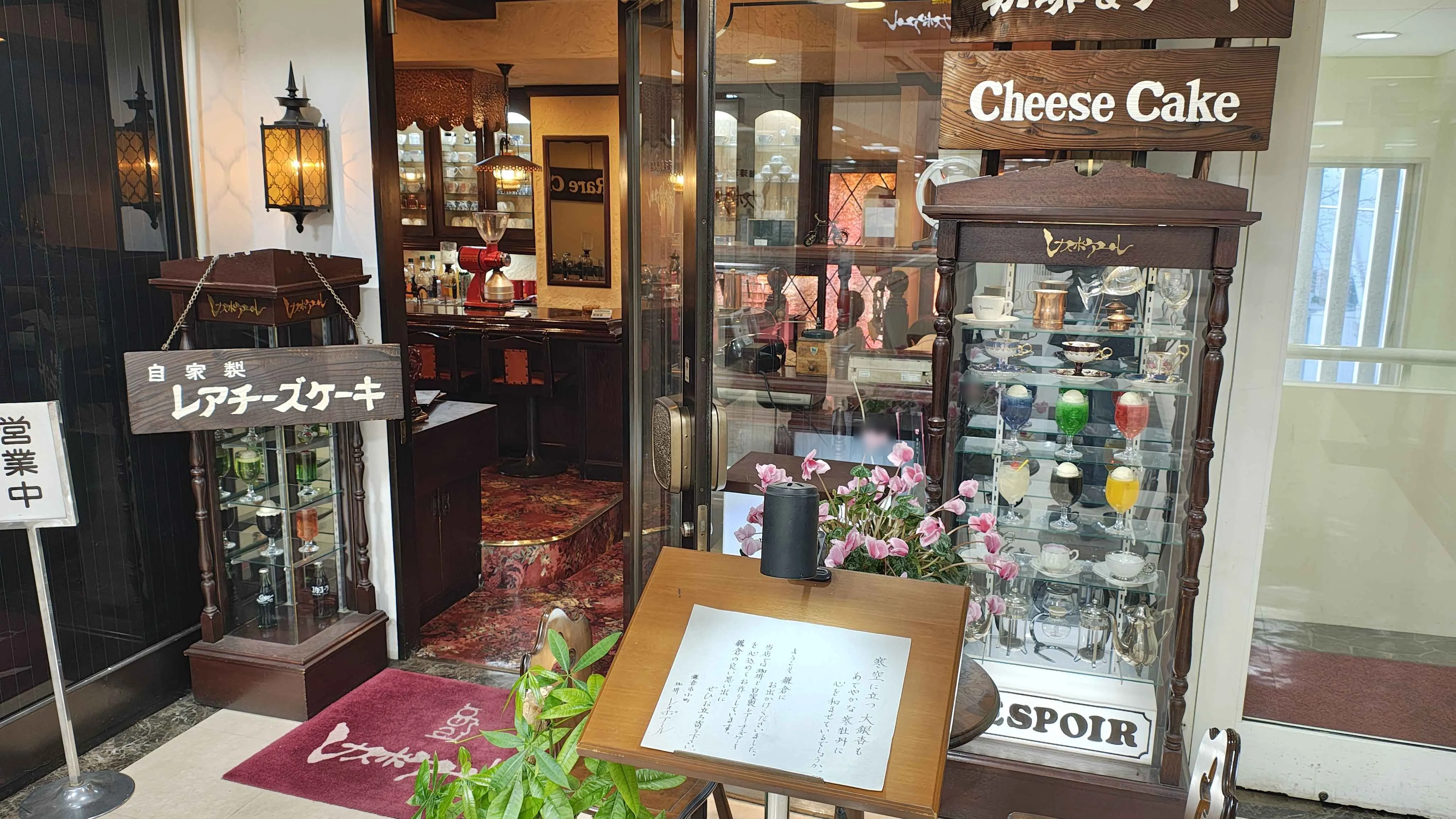 「自家製レアチーズケーキ」の看板とサンプルケースが出ているレスポワールの入口